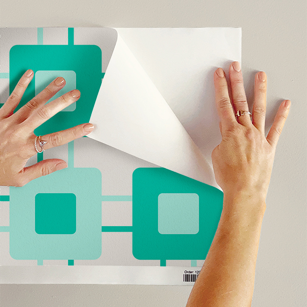 The artwork features a repeating geometric pattern of symmetrical shapes resembling elongated, curved diamonds or petals in various shades of blue and green. Each shape is split vertically with one half filled with a light blue and the other half filled with green or darker blue. The background is a light, almost pastel blue, which provides a soft yet vibrant backdrop. One of the blue shapes near the upper left contains a white starburst element, adding a focal point of brightness to the composition. The overall design conveys a modern, mid-century aesthetic with clean lines and harmonious color contrasts.